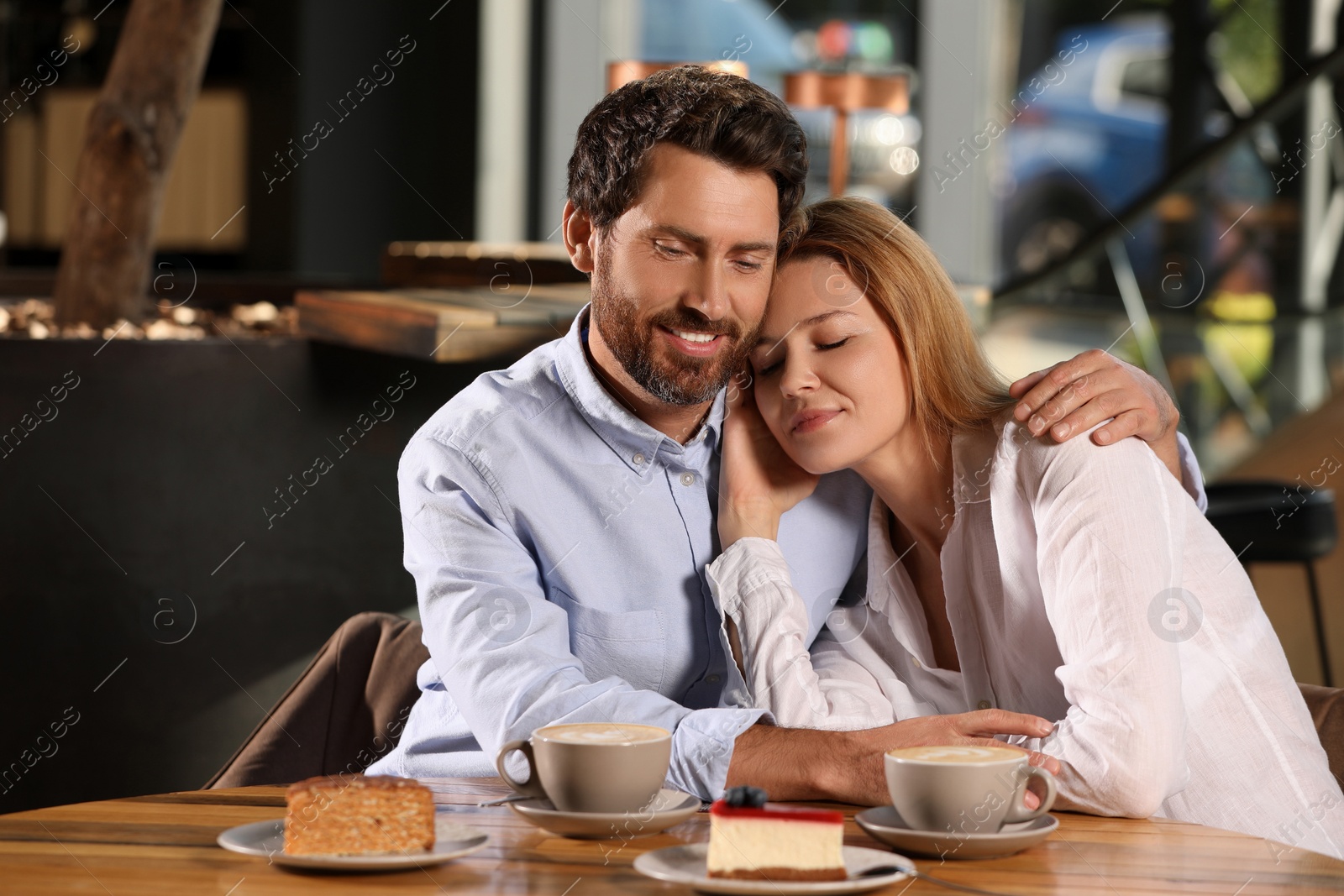 Photo of Romantic date. Lovely couple spending time together in cafe