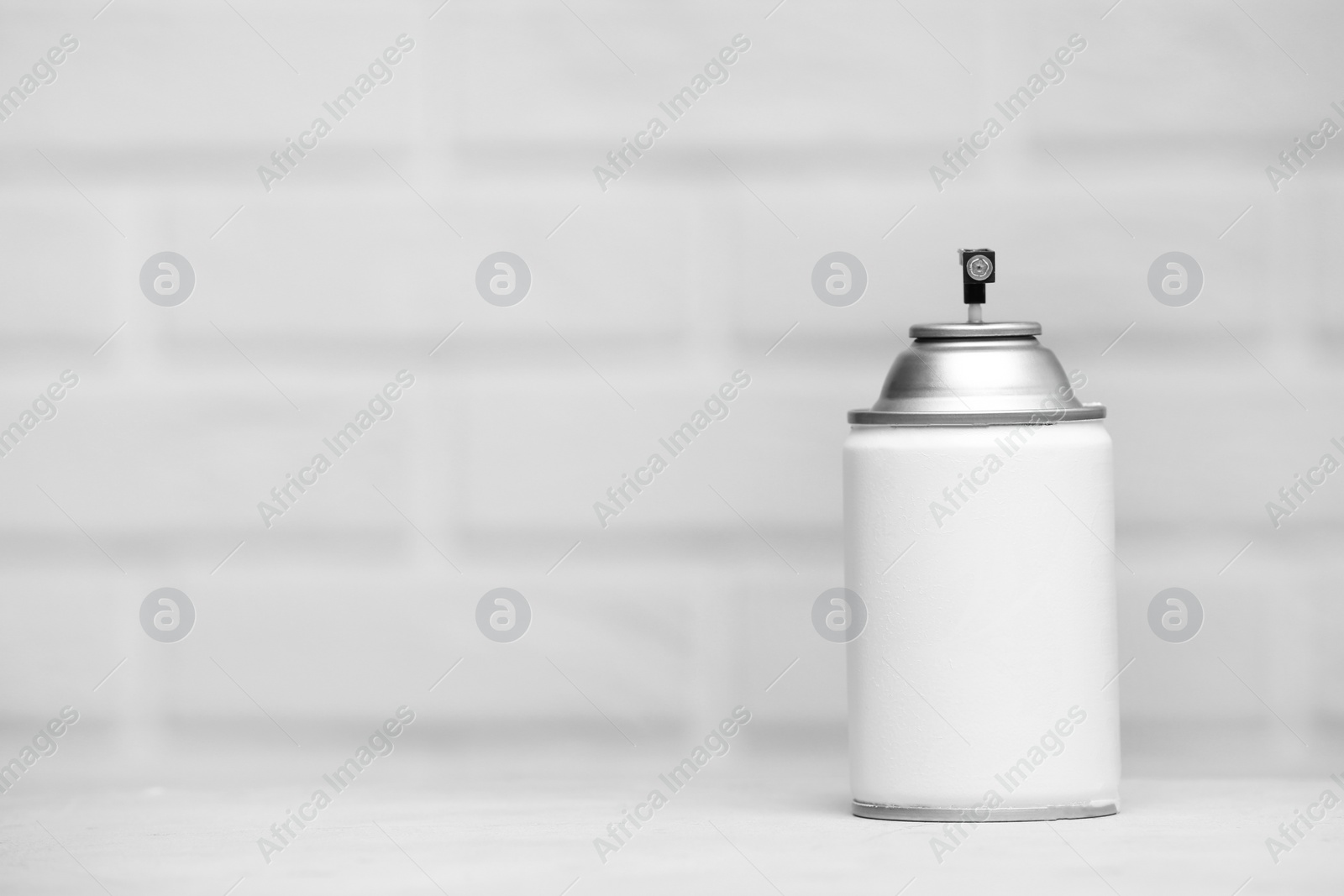 Photo of Spray air freshener on table against light background