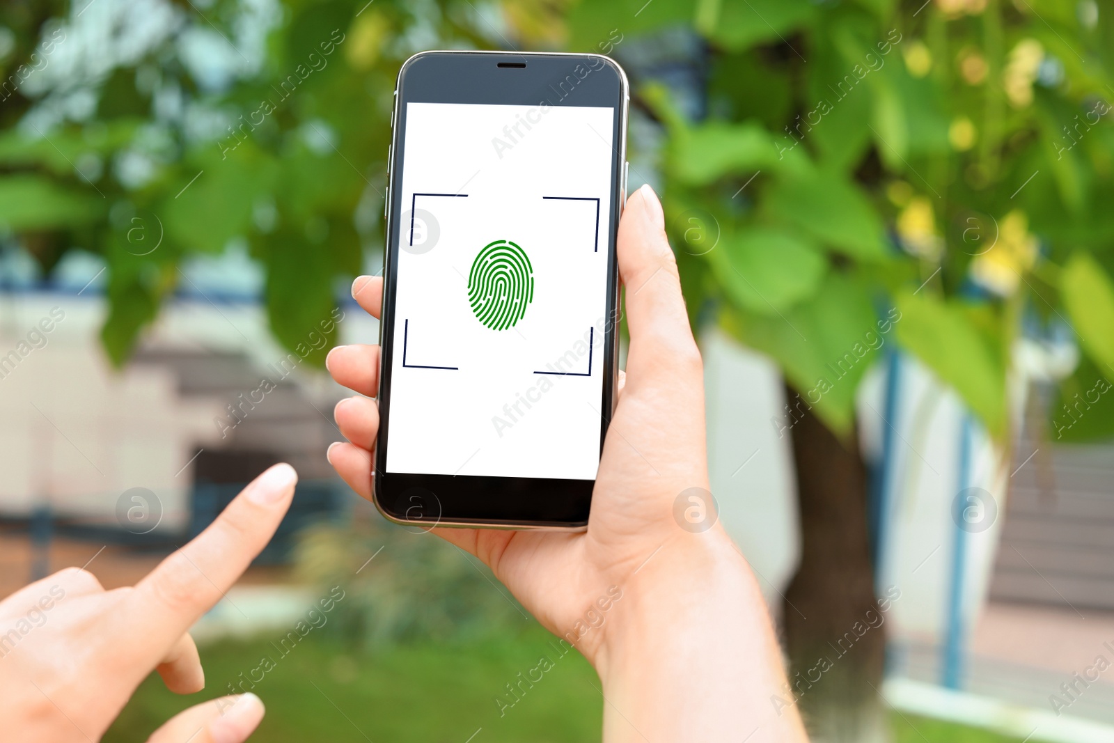 Image of Woman holding smartphone with fingerprint sensor outdoors, closeup. Digital identity