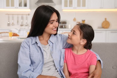 Photo of Happy mother and daughter on sofa at home. Single parenting