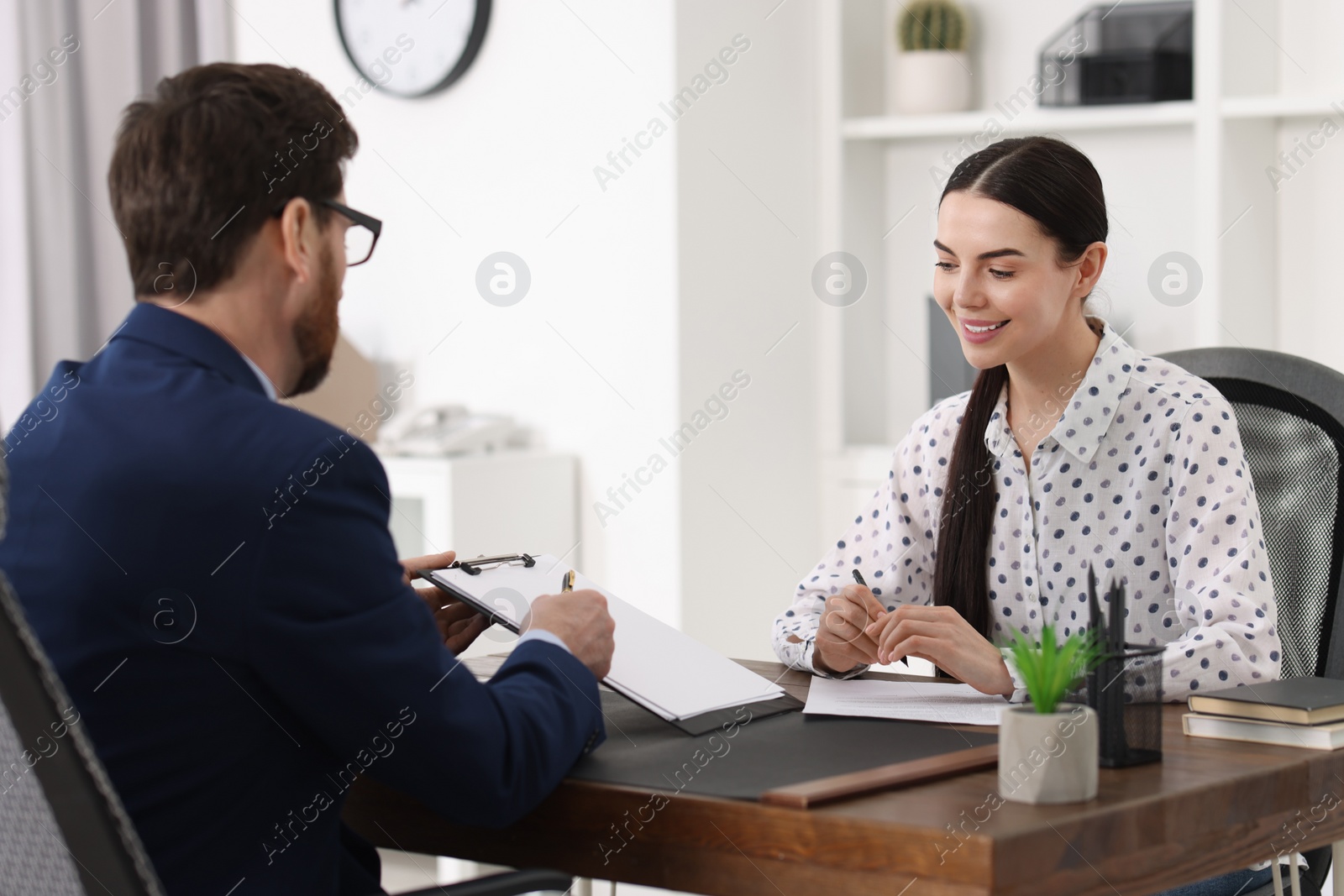 Photo of Young woman having meeting with lawyer in office