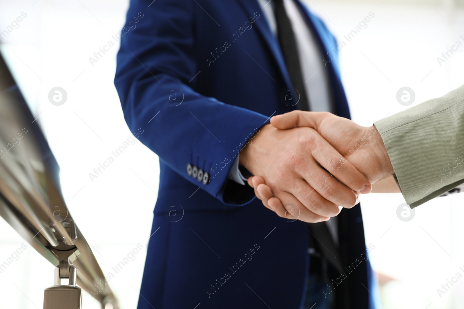 Photo of Business partners shaking hands after meeting, closeup