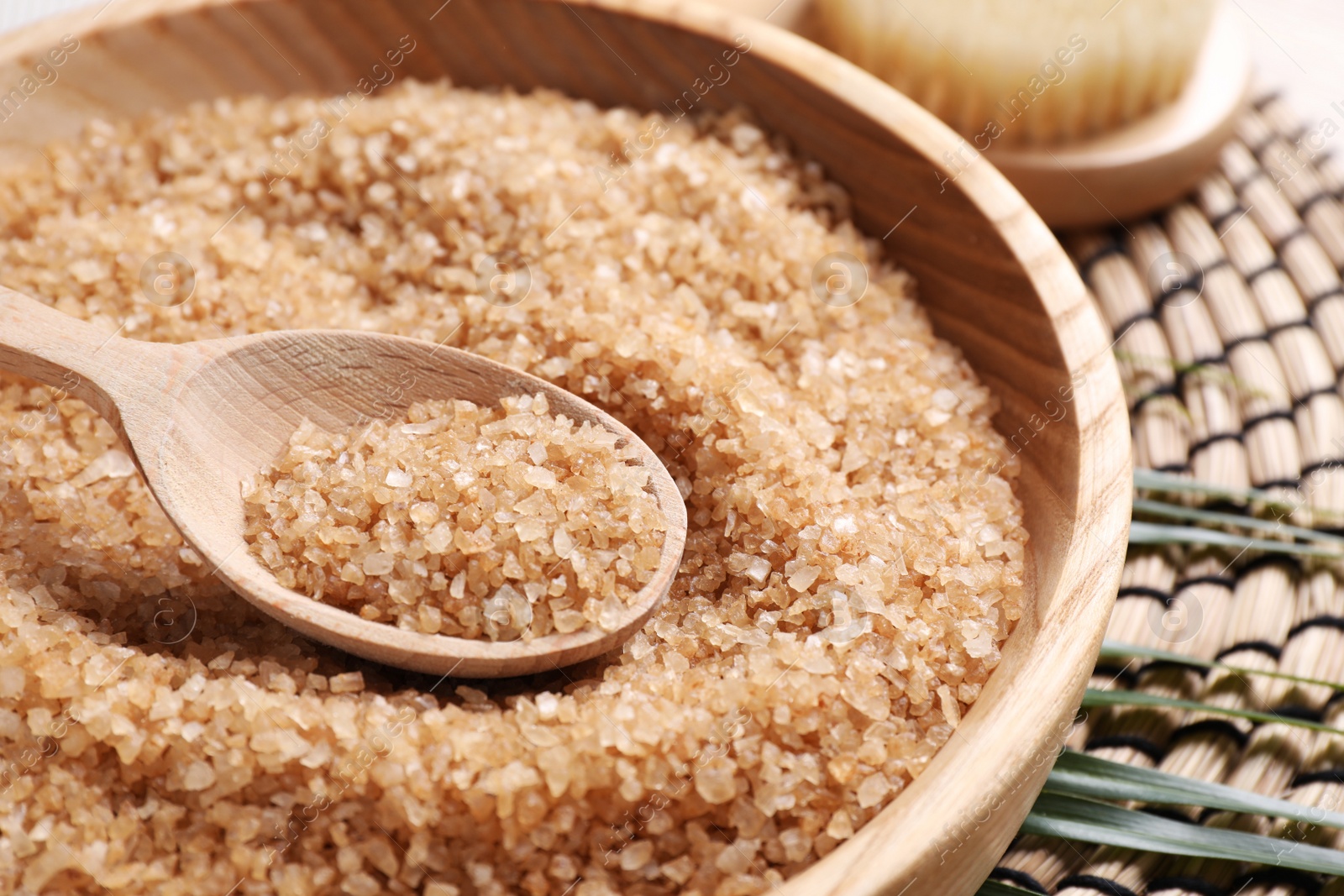 Photo of Salt for spa scrubbing procedure in wooden bowl on table, closeup