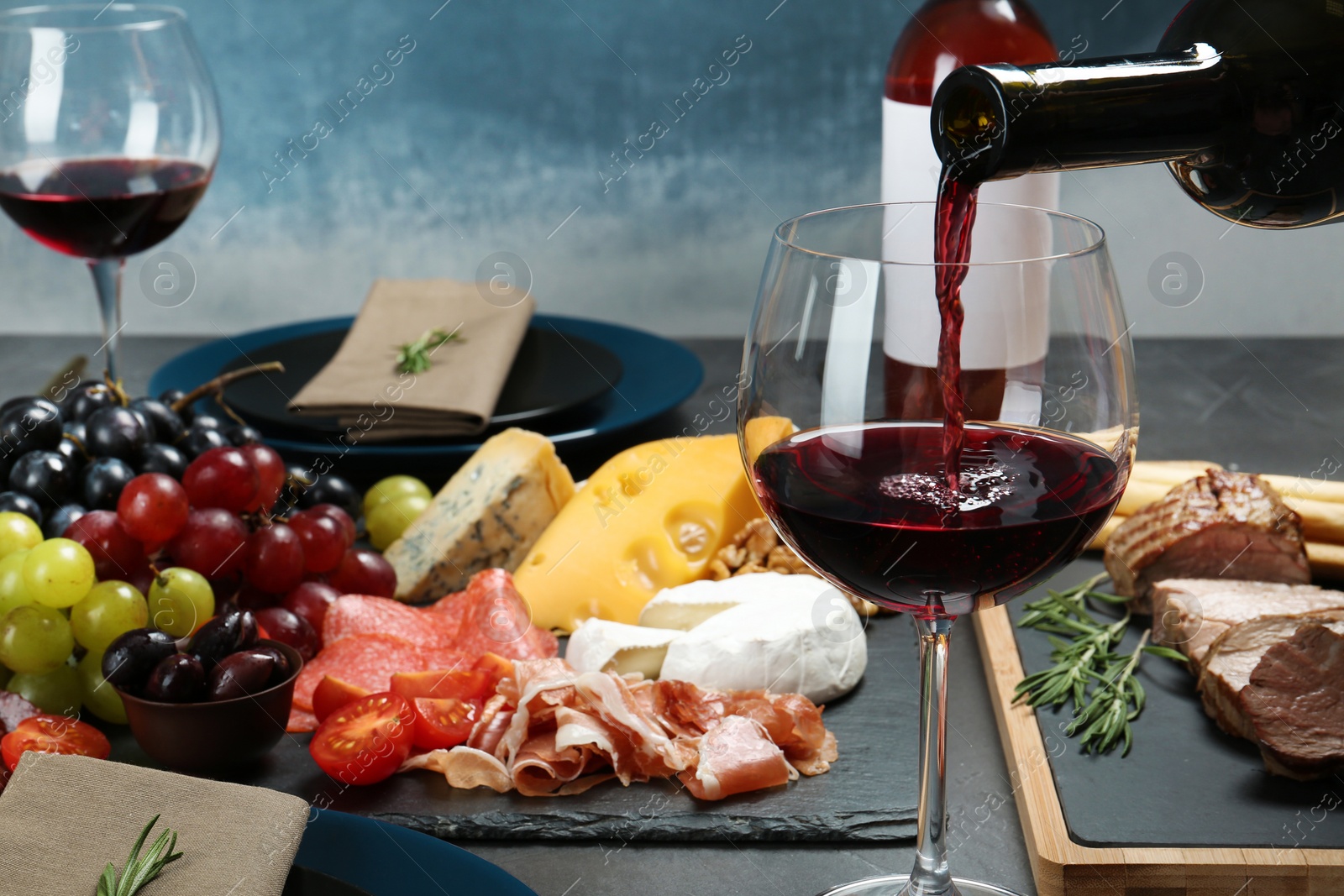 Photo of Pouring red wine into glass on served table at restaurant