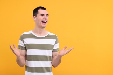 Portrait of surprised man on orange background, space for text