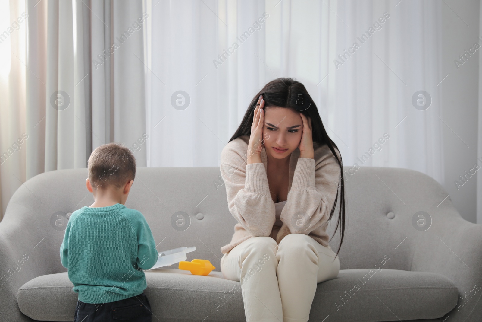 Photo of Depressed single mother with child in living room