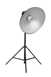 Studio flash light with reflector on tripod against white background. Professional photographer's equipment