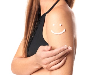 Photo of Woman with smiling face made of sun protection body cream on shoulder against white background, closeup