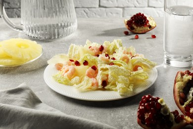 Delicious salad with Chinese cabbage, shrimps and pineapple served on grey table