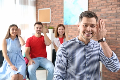 Photo of Young teacher showing sign language gesture against blurred background