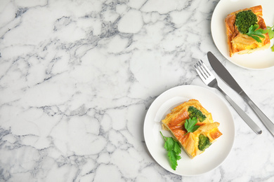 Tasty broccoli casserole served on white marble table, flat lay. Space for text