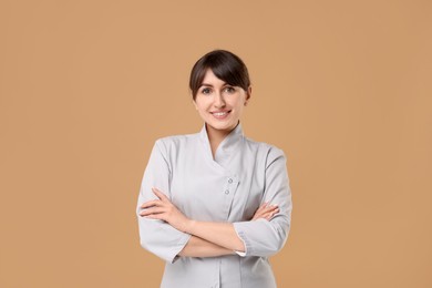 Photo of Cosmetologist in medical uniform on beige background