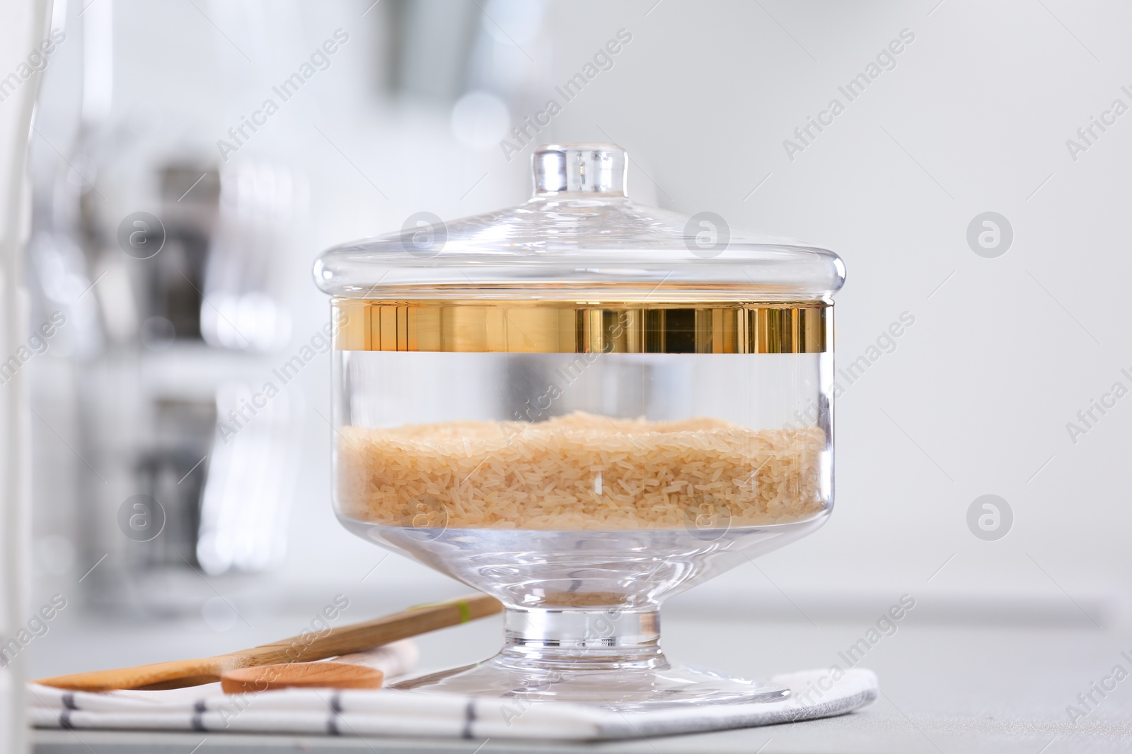 Photo of Jar of raw rice on light grey table in modern kitchen