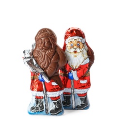 Photo of Sweet chocolate Santa Claus candies in foil wrappers on white background