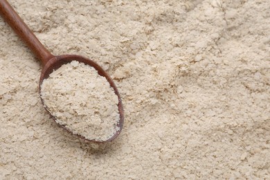 Photo of Wooden spoon of brewer`s yeast on flakes, top view