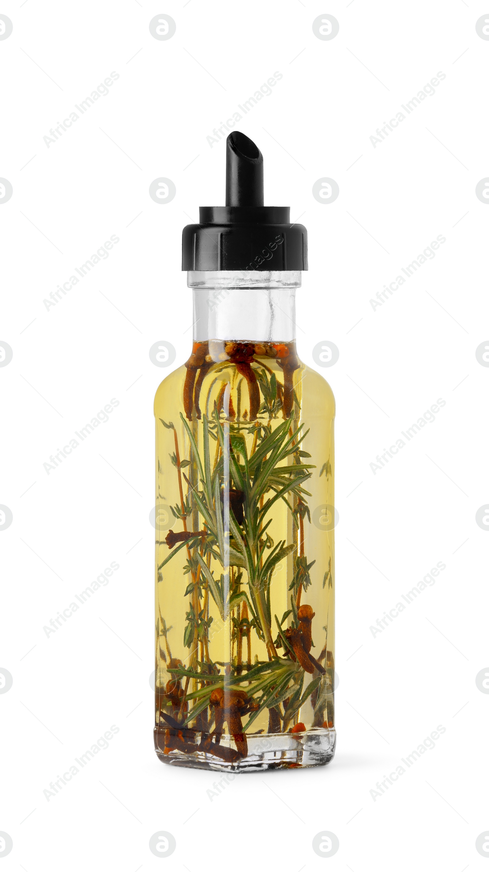 Photo of Glass bottle of cooking oil with spices and herbs isolated on white