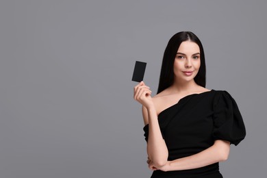 Photo of Woman holding blank business card on grey background. Space for text