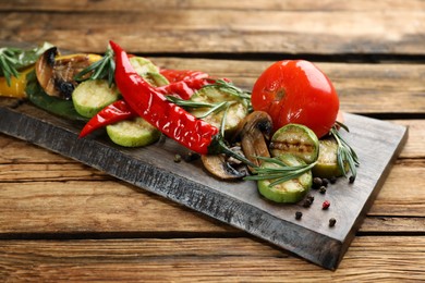 Delicious grilled vegetables with rosemary on wooden table