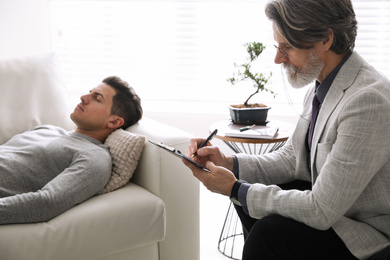 Photo of Psychotherapist and patient in office. Hypnotherapy session