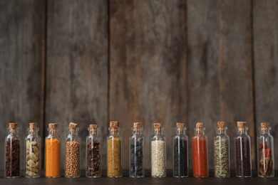 Photo of Bottles with different spices on table against blurred background