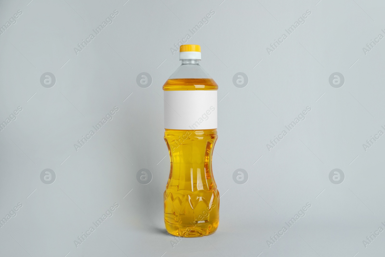 Photo of Bottle of cooking oil on light grey background