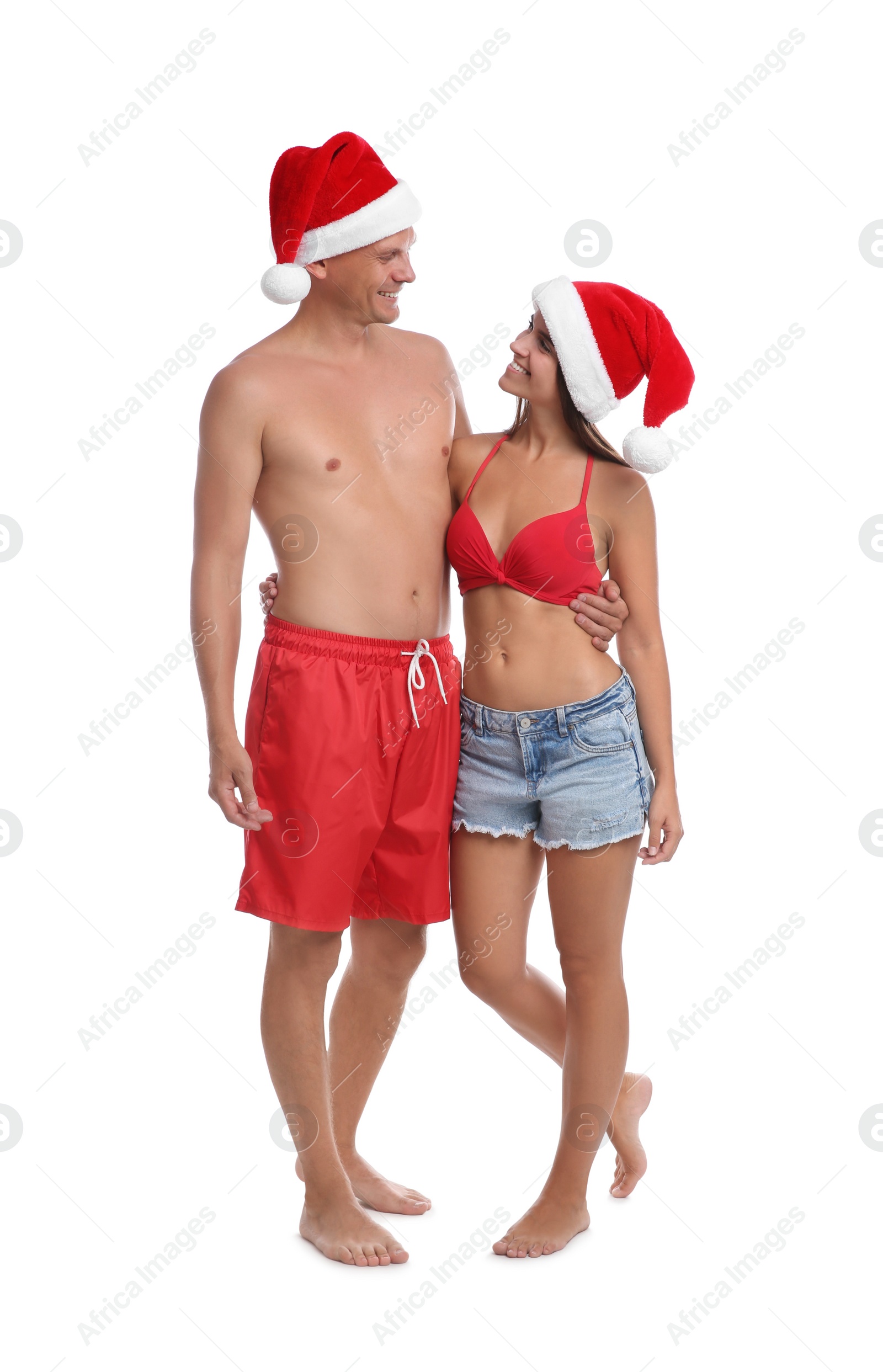 Photo of Happy couple with Santa hats together on white background. Christmas vacation