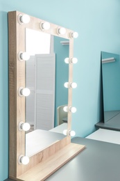 Photo of Makeup mirror with light bulbs on table in dressing room