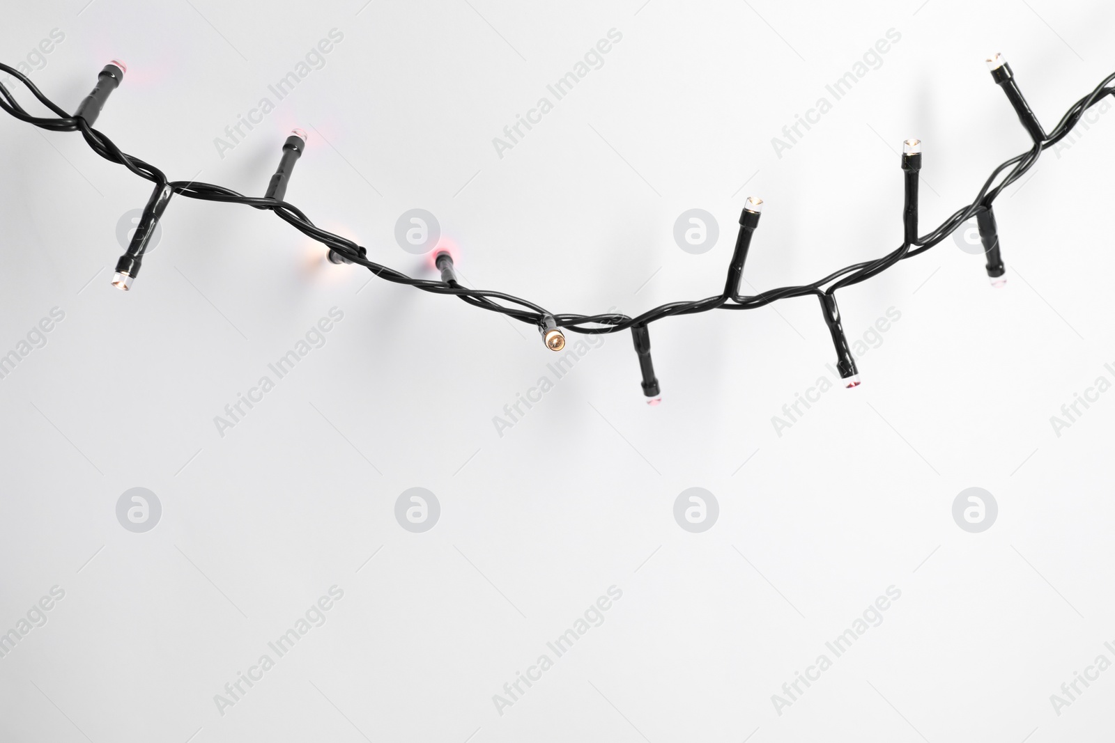 Photo of Beautiful Christmas lights on white background, top view