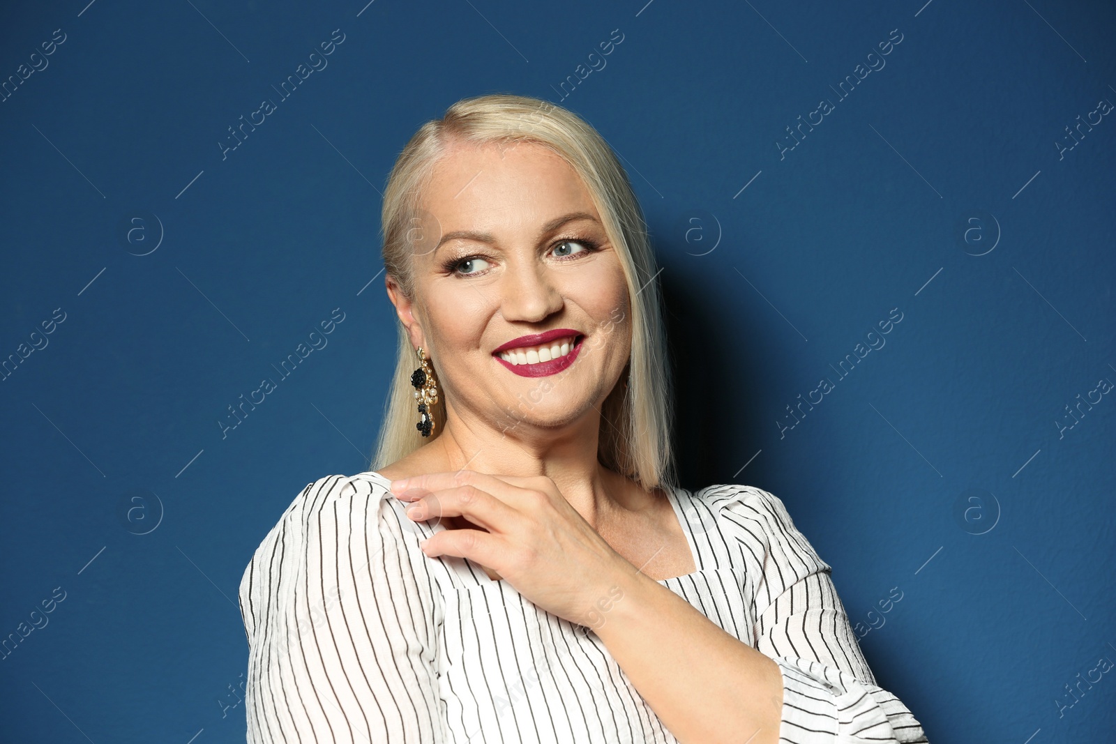 Photo of Portrait of beautiful mature woman on blue background