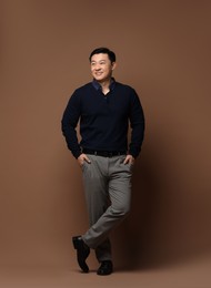 Photo of Full length portrait of happy man on brown background. Space for text