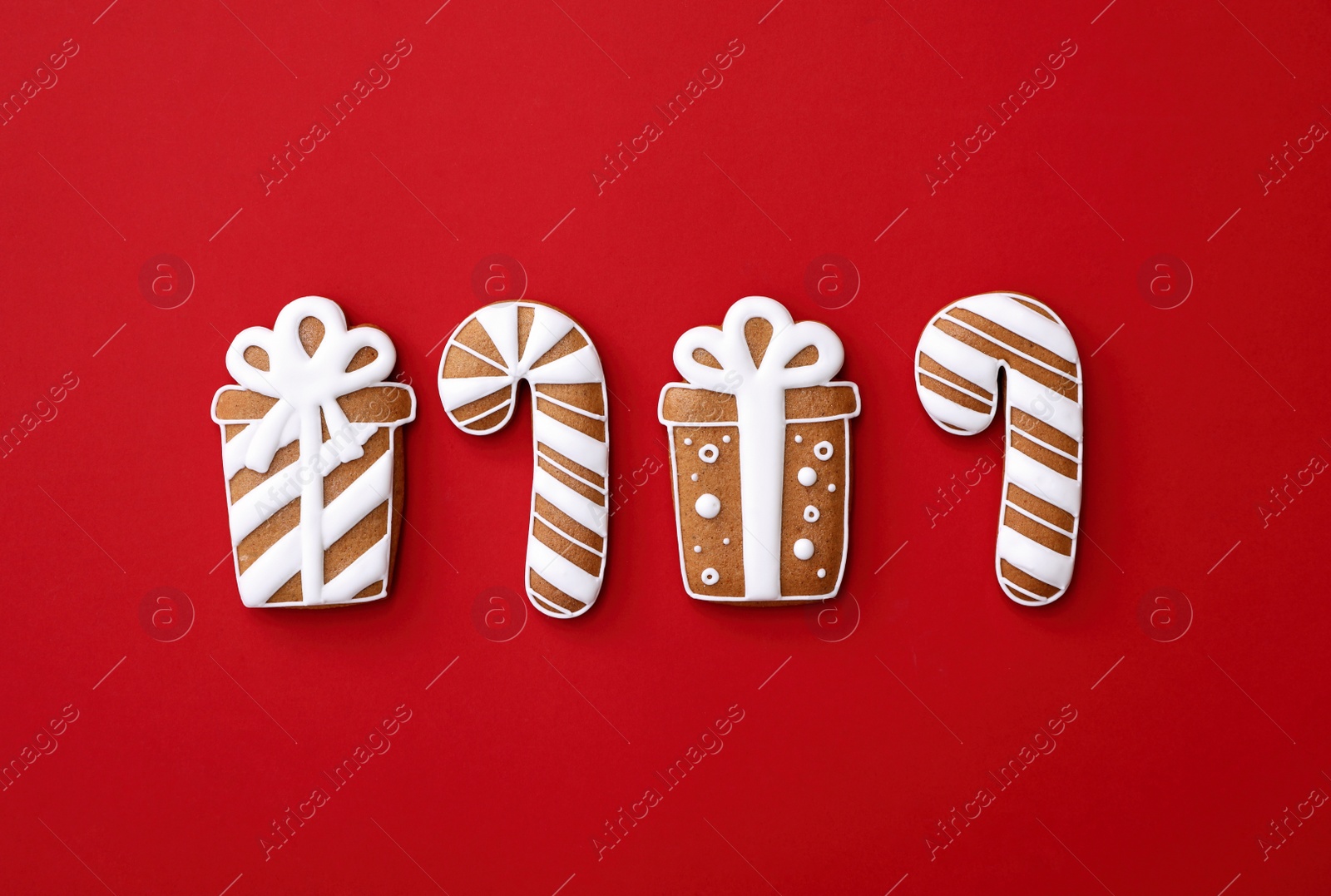 Photo of Different Christmas gingerbread cookies on red background, flat lay