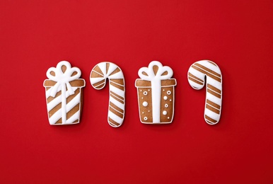 Different Christmas gingerbread cookies on red background, flat lay