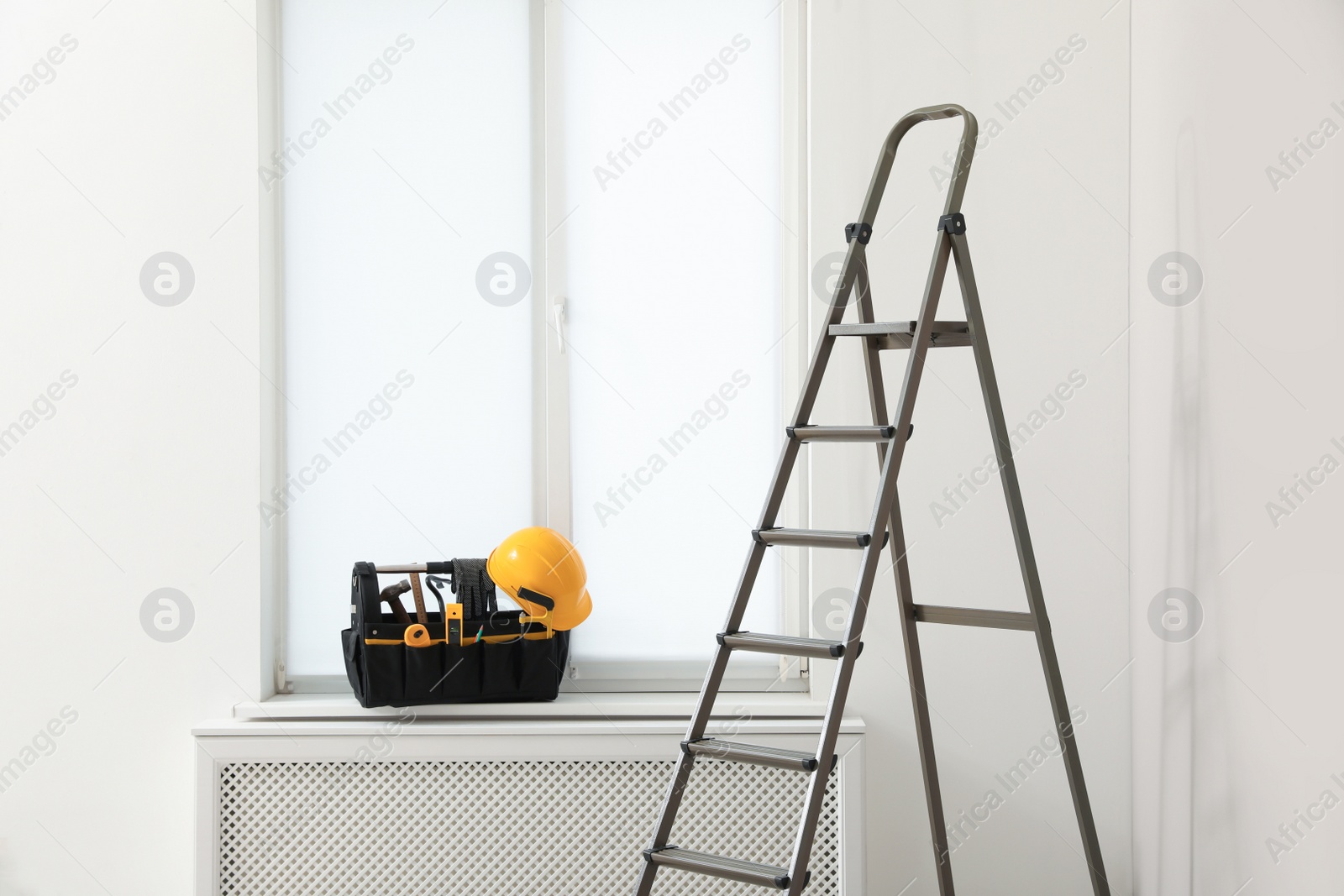 Photo of Window sill with tool box and ladder in room