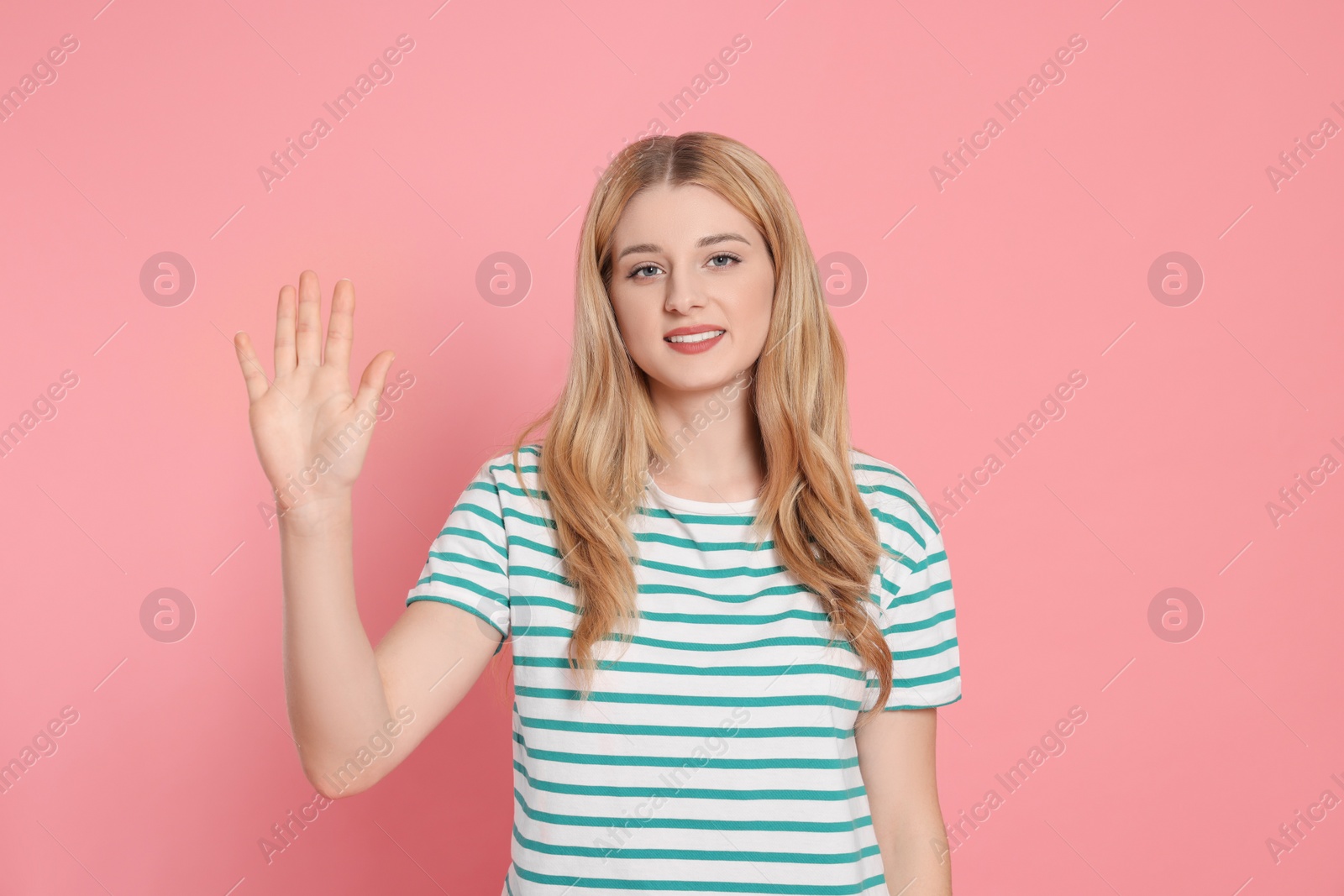 Photo of Happy woman giving high five on pink background