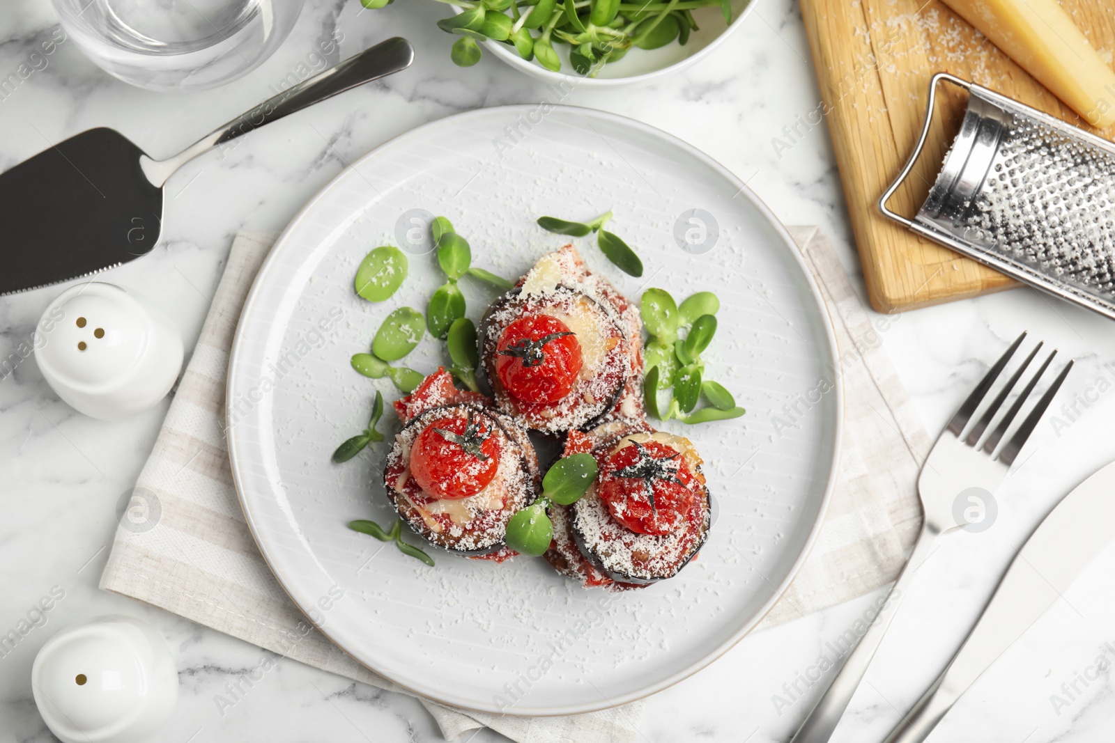 Photo of Baked eggplant with tomatoes, cheese and basil served on white marble table, flat lay