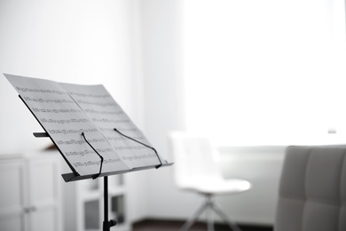 Photo of Note stand with music sheets indoors, space for text