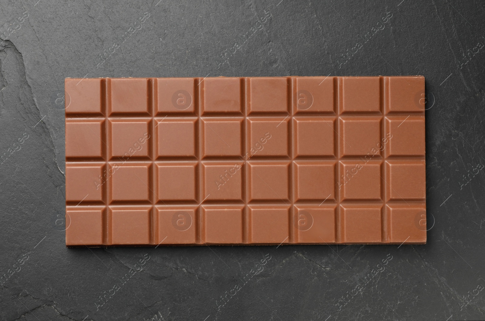 Photo of Tasty chocolate bar on grey table, top view