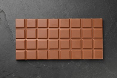 Tasty chocolate bar on grey table, top view