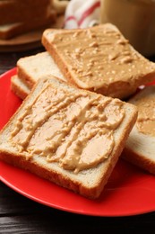 Photo of Delicious toasts with peanut butter on table, closeup