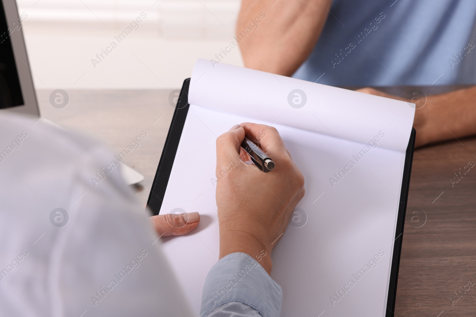 Photo of Doctor with clipboard in clinic, closeup. Patient consultation