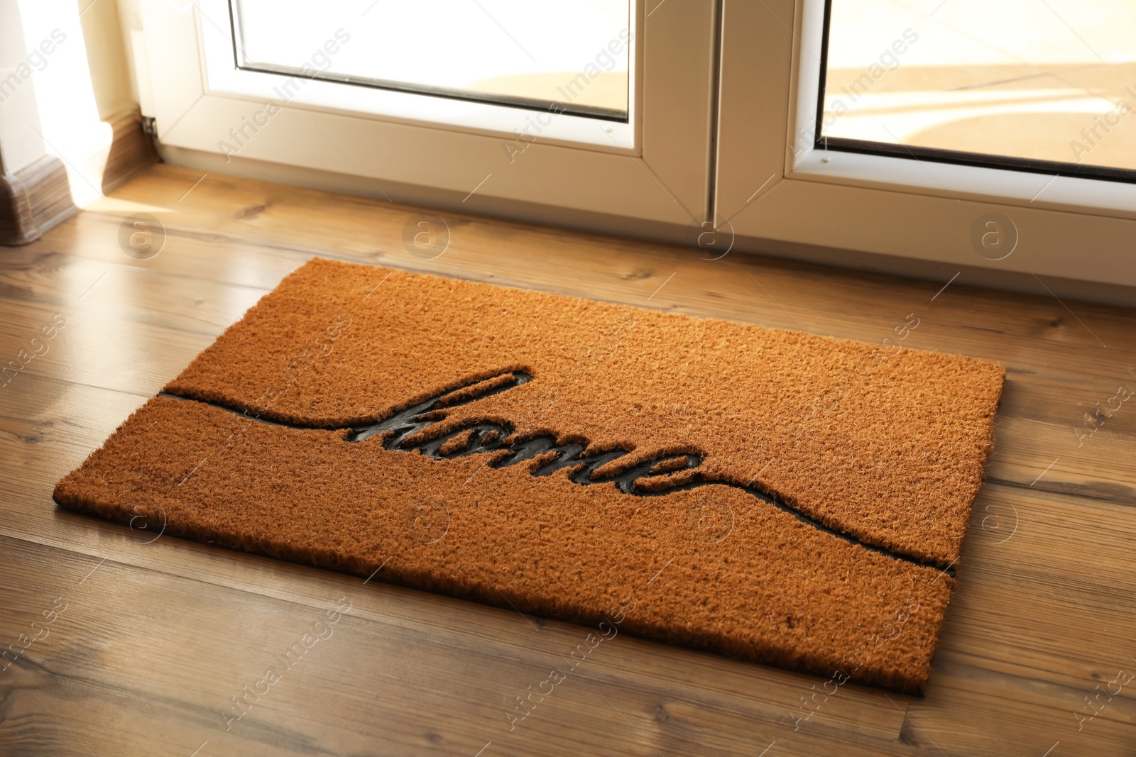 Photo of Doormat with word Home on parquet floor indoors