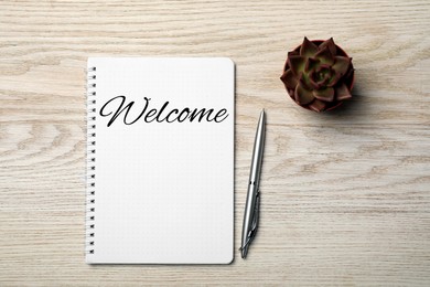 Image of Notebook with word Welcome, pen and houseplant on wooden table, flat lay