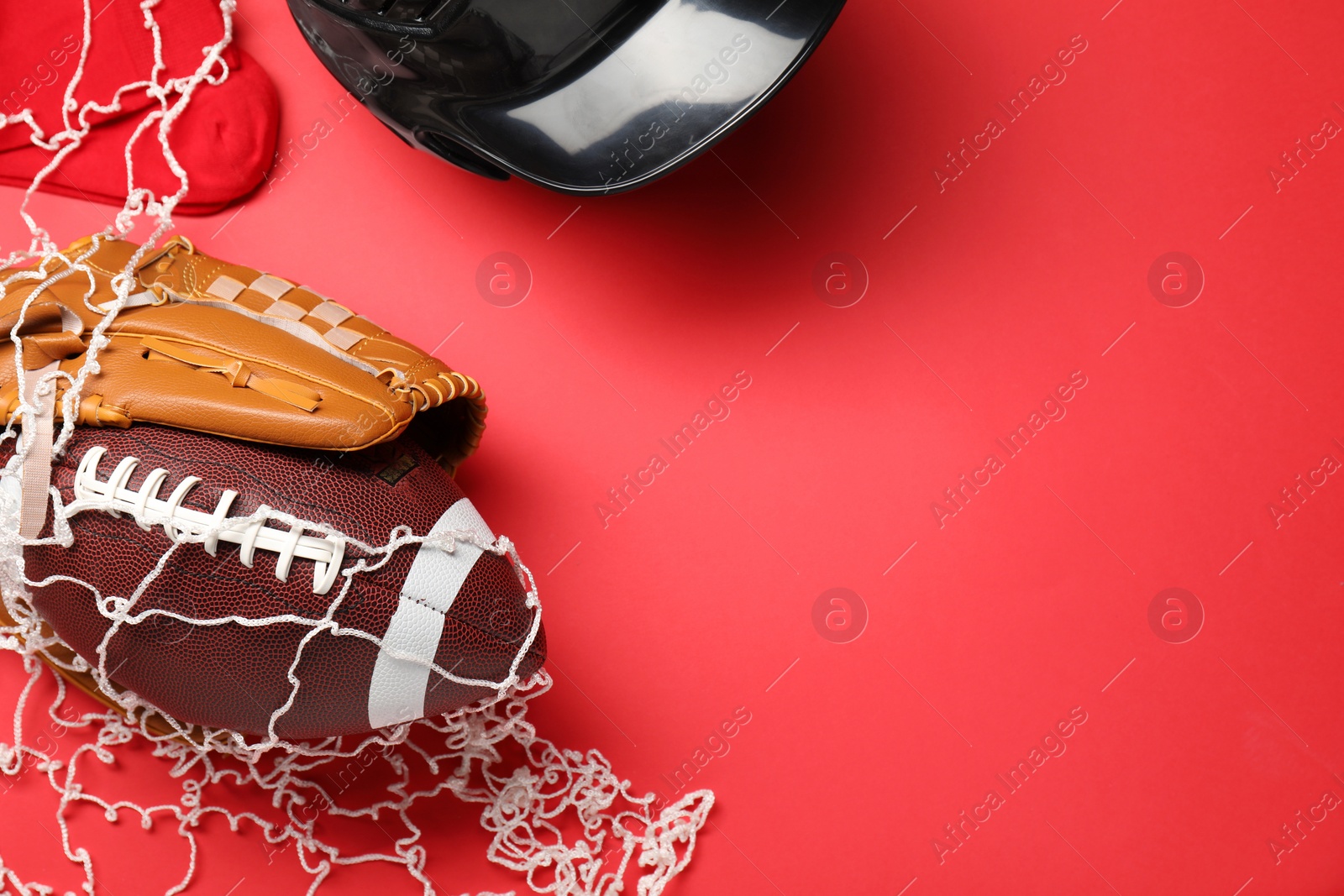 Photo of Sports equipment. Baseball glove, ball, socks and helmet on red background, flat lay. Space for text