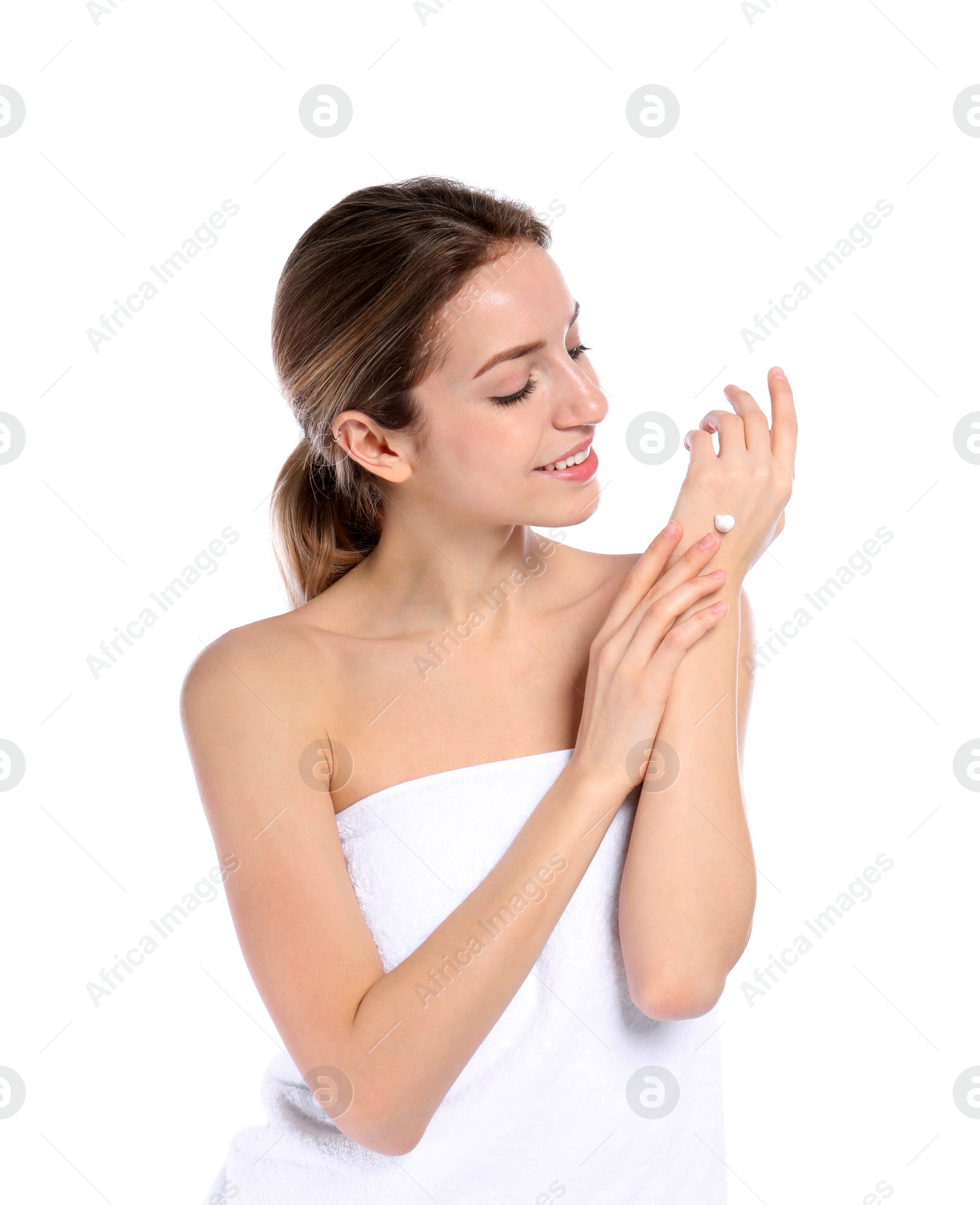 Photo of Young woman applying cream on her hand against white background. Beauty and body care