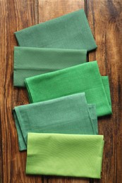 Photo of Different kitchen napkins on wooden table, flat lay