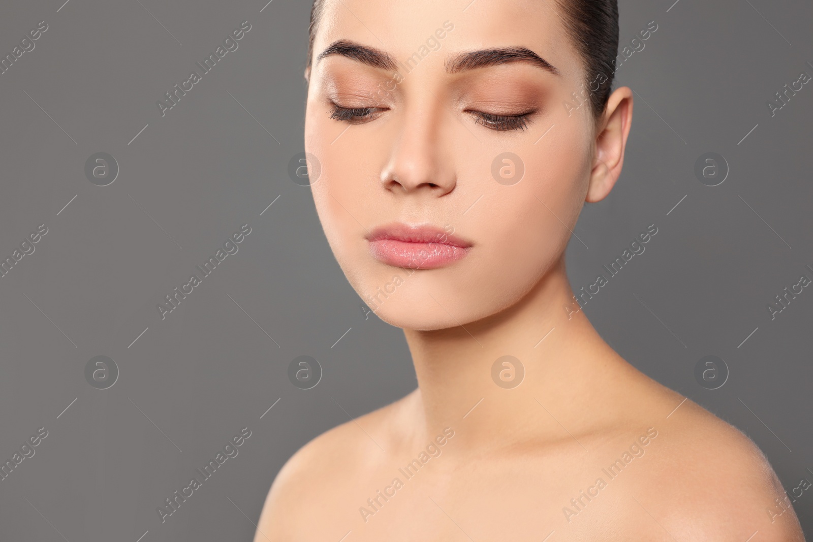 Photo of Portrait of young woman with beautiful face and natural makeup on color background, closeup