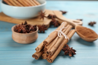 Aromatic cinnamon and anise on light blue wooden table, closeup