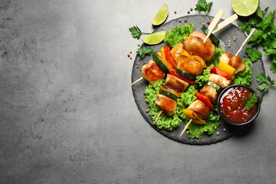 Photo of Delicious chicken shish kebabs with vegetables on grey table, flat lay. Space for text