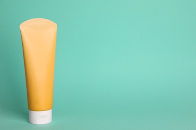 Photo of Tube of face cleansing product on turquoise background. Space for text
