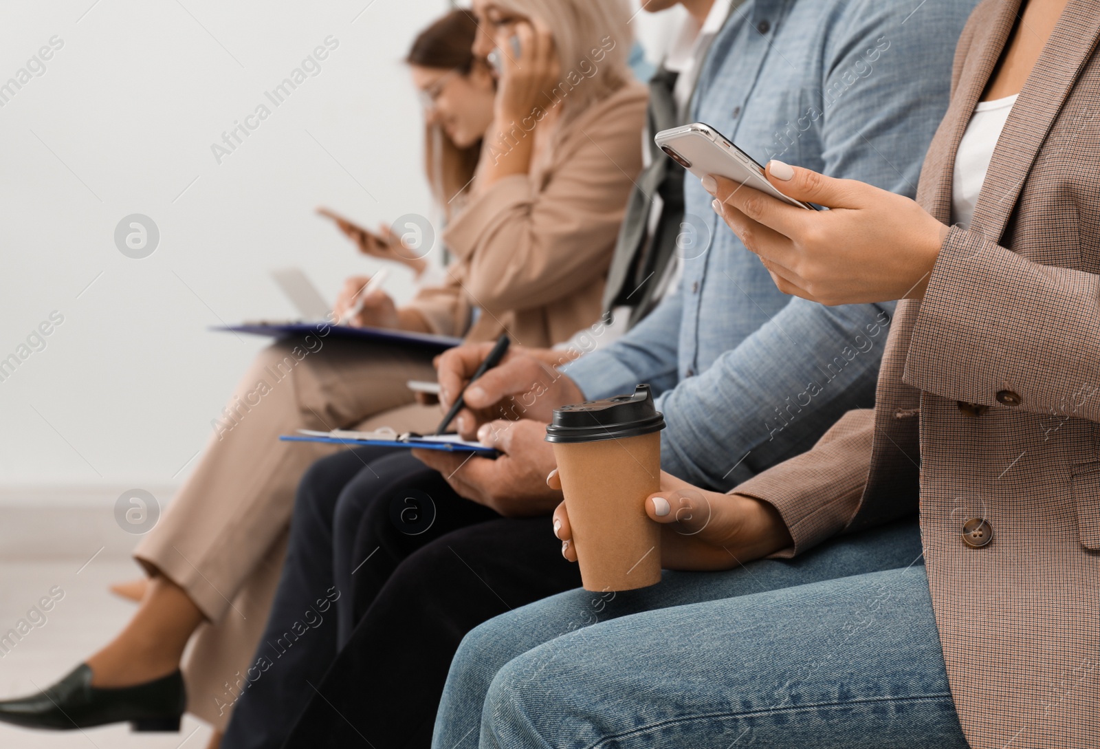 Photo of Woman with phone and cup of coffee waiting for interview in office, closeup